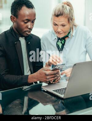business colleagues discussing online news in the workplace. Stock Photo