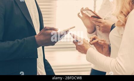 young business people reading messages on their smartphones Stock Photo