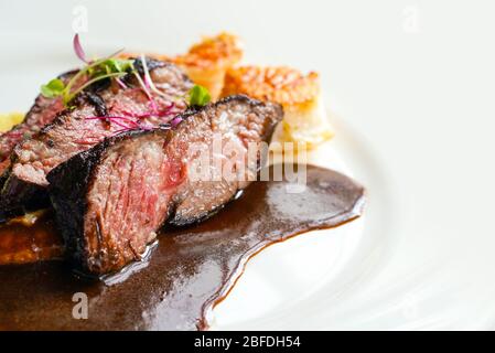 72hrs. seared beef short ribs served on white plate. Stock Photo