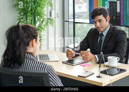 Young employers in black suits are evaluating job applicants by asking marketing strategy questions. Candidate didn't understand what the employer was Stock Photo