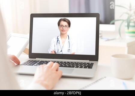 Portrait of a smiling female doctor consulting patient by video call in online chat on computer. Stock Photo
