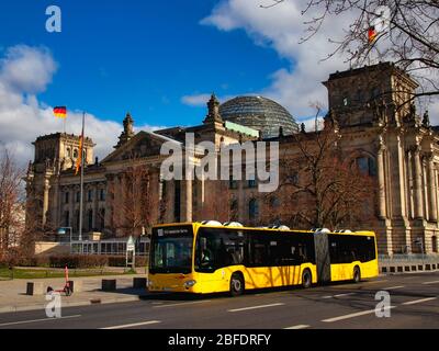 Berlin, Germany - March 21, 2020 - Public transport bus (BVG / Berliner Verkehrsbetriebe) in front of the Reichstag building (Bundestag) Stock Photo