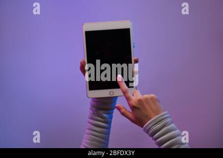 Close-up of man's hands with smartphone and blank black screen on blank purple background. Place for text Stock Photo