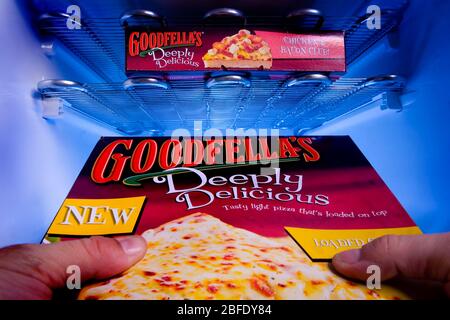 A man taking out a Goodfellas pizza from a deep freezer Stock Photo