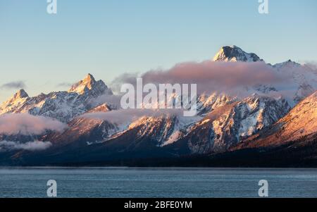 Mountain range covered by snow and cloud at sunrise of Jackson Lake, Grand Teton National Park, Wyoming, USA. Stock Photo