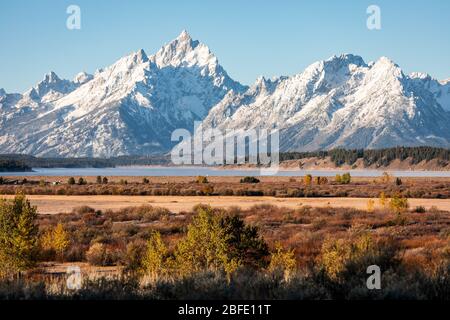 Snow cover mountain peak of Grand Teton and Mount Moran outstanding in blue sky beside Jackson Lake and Willow Flats of Grand Teton, Wyoming, USA.