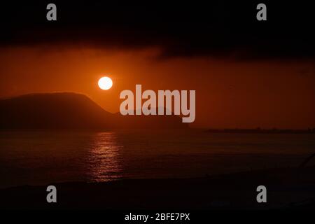 Fiery sun at sunset over pacific ocean in Peru Stock Photo