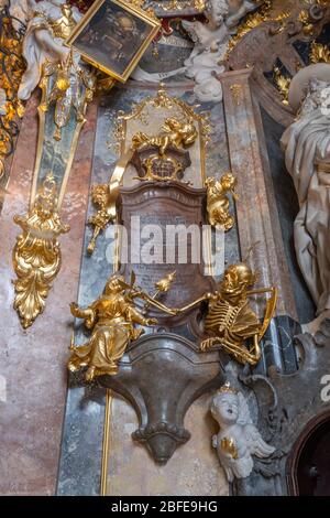 Feb 2, 2020 - Munich, Germany: Golden skeleton statue on mural at entrance to Asamkirche Baroque church in Munchen Stock Photo