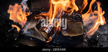 Fire flames with sparks on  coals on black background. Stock Photo