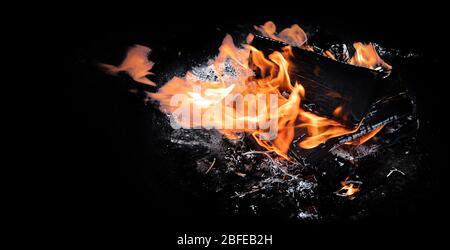 Fire flames with sparks on  coals on black background. Image with copy space Stock Photo