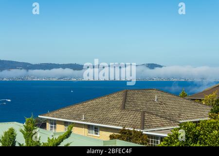 Hobart, Tasmania, Australia - December 24 2016: Hobart city and derwent river viewed from suburb of sandy bay with sea mist rolling over eastern shore Stock Photo