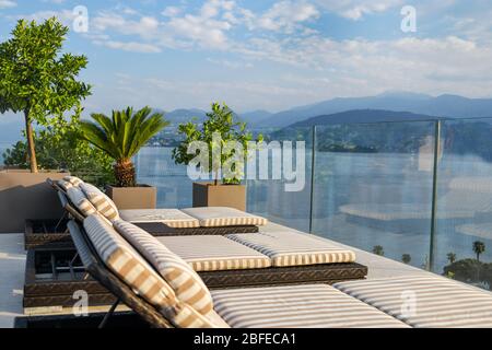 Sun loungers overlooking Lake Maggiore in Italy Stock Photo