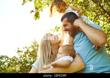 Happy parents with children in the park at sunset. Stock Photo