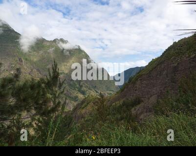 Outlook on the way to Cilaos with light effects on the mountains under cloudy sky in Reunion Island Stock Photo