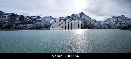 panorama shot in the alps in autumn with snowy mountains in the background and water of the silvretta dam in the foreground Stock Photo