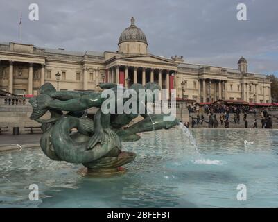 Fountain statues on Trafalgar square in London with old building Stock Photo
