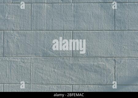 Big stone look facade plastered building wall painted white and looking like big stones Stock Photo