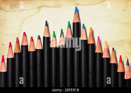 A business bar chart composed of the sharpened ends of a set of professional artist's colored pencils on a dirty linen fiber paper background. Room fo Stock Photo