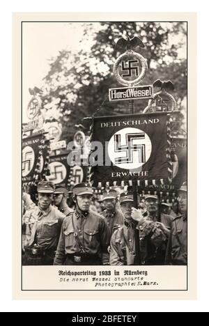 Archive vintage 1930's Nazi Propaganda image with Sturmabteilung Troops (Storm Detachment) and banner flags 'Reichsparteitag Nürnberg 1933' , 'Freedom and Bread Nazi Party Rally Nuremberg 1-3 September 1933', with flag standard 'Deutschland Erwache' 'GERMANY AWAKES' 'Freiheit und Brot Reichsparteitag Nürnberg 1.-3 September 1933', Nazi Germany 1933, 'Freiheit und Brot Reichsparteitag Nürnberg 1-3 September Germany Stock Photo