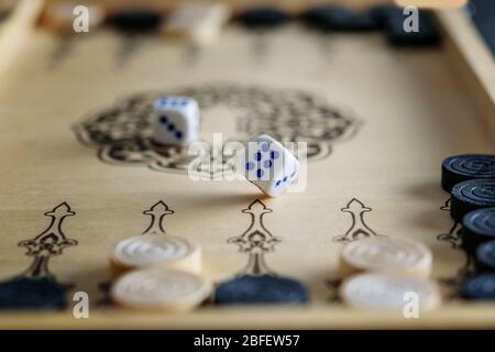Game dices closeup on the backgammon wooden board. Staying home, enjoying life. Stock Photo