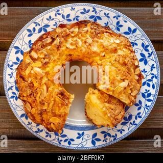 Delicious homemade apple and almond cake on decorated white plate and wooden background Stock Photo