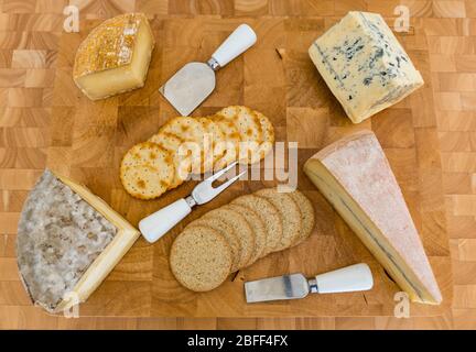 Cheeseboard: artisan cheeses Gorwydd Caerphilly (Wales), Sheep Rustler (Somerset), Cashel Blue cheese (Ireland) & Morbier (France) crackers & oatcakes Stock Photo