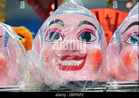 Plastic smiling masks wrapped in cellophane Stock Photo