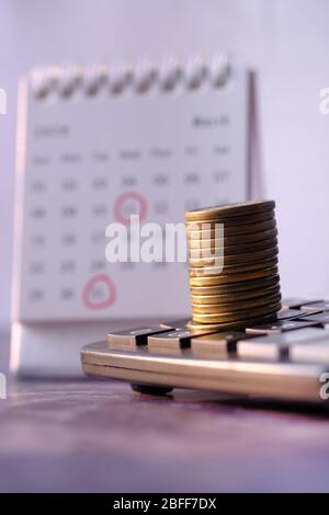 Close up of stack of coins on calculator, Stock Photo