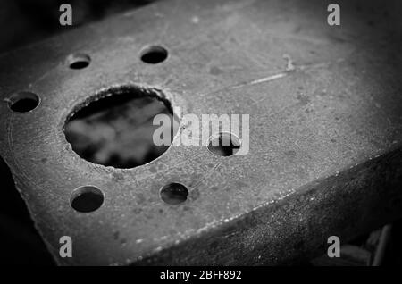 Drilled holes in the metal channel. Massive metal part with seven structural holes. Industrial background. Close-up. Selective focus. Stock Photo