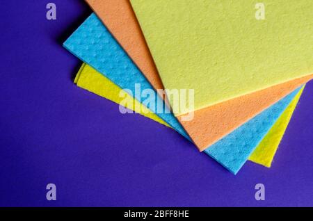 Kitchen napkins on a blue background. Five multi-colored cleaning napkins. Commercial cleaning company. Close-up. Selective focus. Stock Photo
