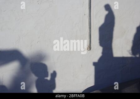 Shadow of a child praying to the statue of the Madonna Stock Photo