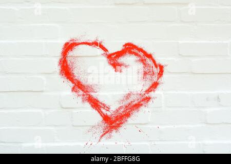 A red heart painted on a white brick wall Stock Photo