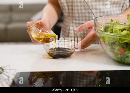 Hands mix oil with sauce at bowl Stock Photo