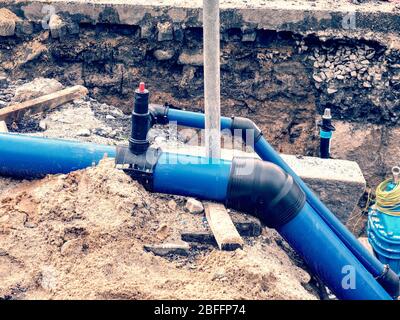 Replacing of broken pipes with PVC tubes for water delivery. Drink water piping with 250mm waga multi joint member. Stock Photo