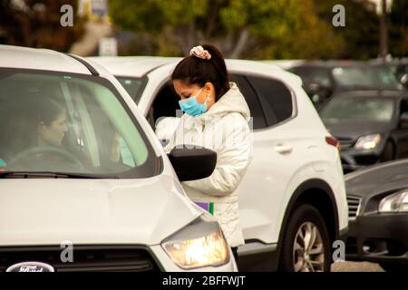 Wearing a safety face mask, a nurse collects data from patients at a drive through blood testing facility in a Westminster, CA, mall for Coronavirus or COVID-19. Stock Photo