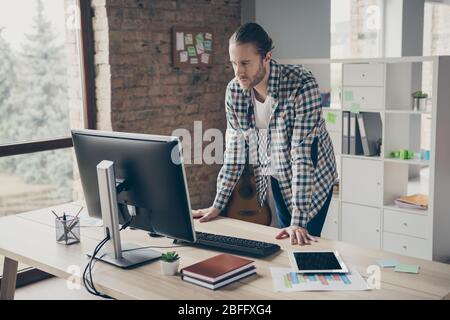 Photo of handsome business guy look computer monitor table waiting colleagues partners answer seriously reading report wear casual shirt standing Stock Photo
