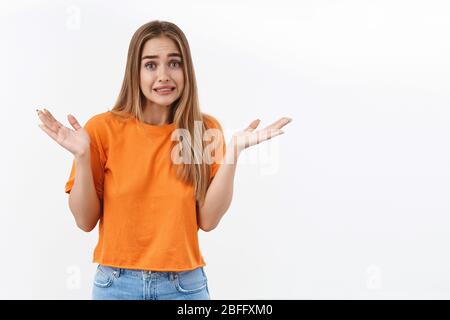 Oops, sorry my mistake. Portrait of worried cute insecure blond girl apologizing for cant help, dont know anything, clench teeth and make awkward Stock Photo