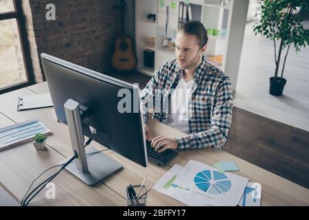 Photo of handsome business guy look computer monitor table chatting colleagues seriously read corporate report wear casual shirt suit sitting chair Stock Photo