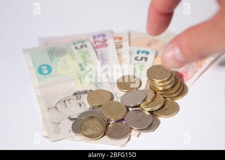 Illustrative image of various denomination sterling pound notes and coins. Stock Photo