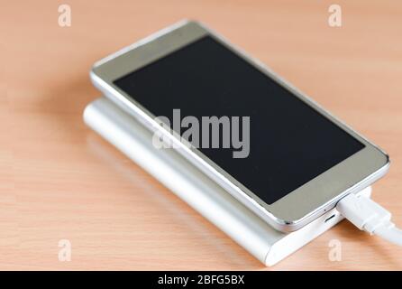 Close-up of usb  fast charge power bank charging a smartphone .External  battery  for recharging  portable devices . Stock Photo