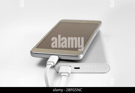 Close-up of  external battery that charges a discharged  mobile phone . Fast charging  powerbank electricity storage . Stock Photo