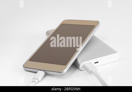 Close-up of  external battery that charges a discharged  mobile phone . Fast charging  powerbank electricity storage . Stock Photo