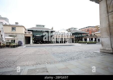 London, UK. 18th Apr, 2020. Day Twenty Six of Lockdown in London. Midday and Covent Garden Market is deserted on a very quiet central London for a Saturday as the country is on lockdown due to the COVID-19 Coronavirus pandemic. People are not allowed to leave home except for minimal food shopping, medical treatment, exercise - once a day, and essential work. COVID-19 Coronavirus lockdown, London, UK, on April 18, 2020 Credit: Paul Marriott/Alamy Live News Stock Photo