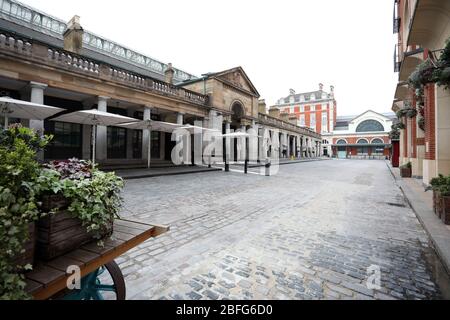 London, UK. 18th Apr, 2020. Day Twenty Six of Lockdown in London. Midday and Covent Garden Market is deserted on a very quiet central London for a Saturday as the country is on lockdown due to the COVID-19 Coronavirus pandemic. People are not allowed to leave home except for minimal food shopping, medical treatment, exercise - once a day, and essential work. COVID-19 Coronavirus lockdown, London, UK, on April 18, 2020 Credit: Paul Marriott/Alamy Live News Stock Photo