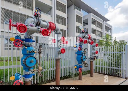 A fire (water pump) hydrant booster valve outside a modern apartment block in Sydney, Australia Stock Photo