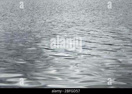 Silver reflections on the waters of a lake. Full frame texture detail. Stock Photo