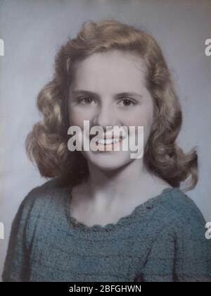 1947 High school graduation photo of a blonde woman with brown eyes and wearing a blue sweater. The sepia photo is enhances with watercolor. Stock Photo