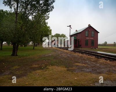 Restored wooden train depot with tracks and a train car at the Big Horn County Historical Museum. Stock Photo