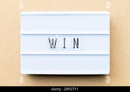 White lightbox with word win on wood background Stock Photo