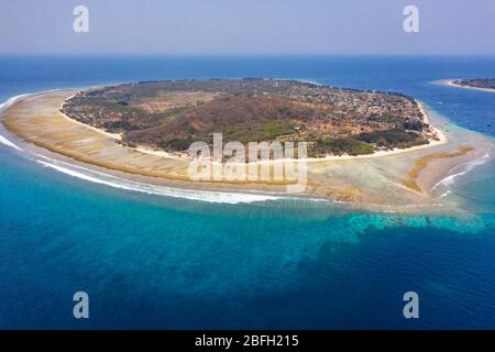 Aerial drone view of a dry, tropical island surrounded by fringing coral reef (Gili Trawangan, Indonesia) Stock Photo